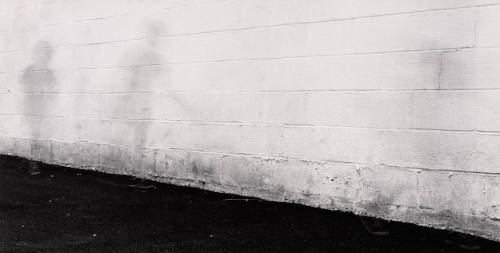 [Ghostly figures in front of white wall]