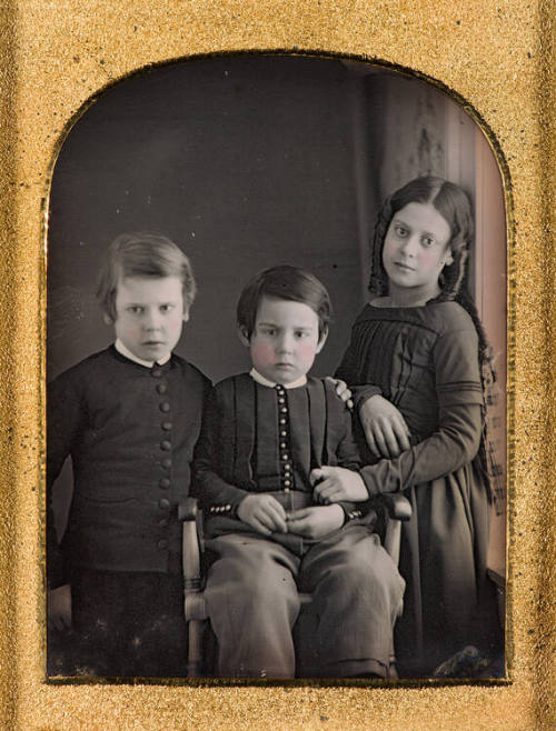 Young girl with brothers by window