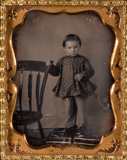 Child beside chair
