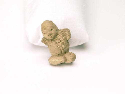 Fragment of small seated human figure of pottery