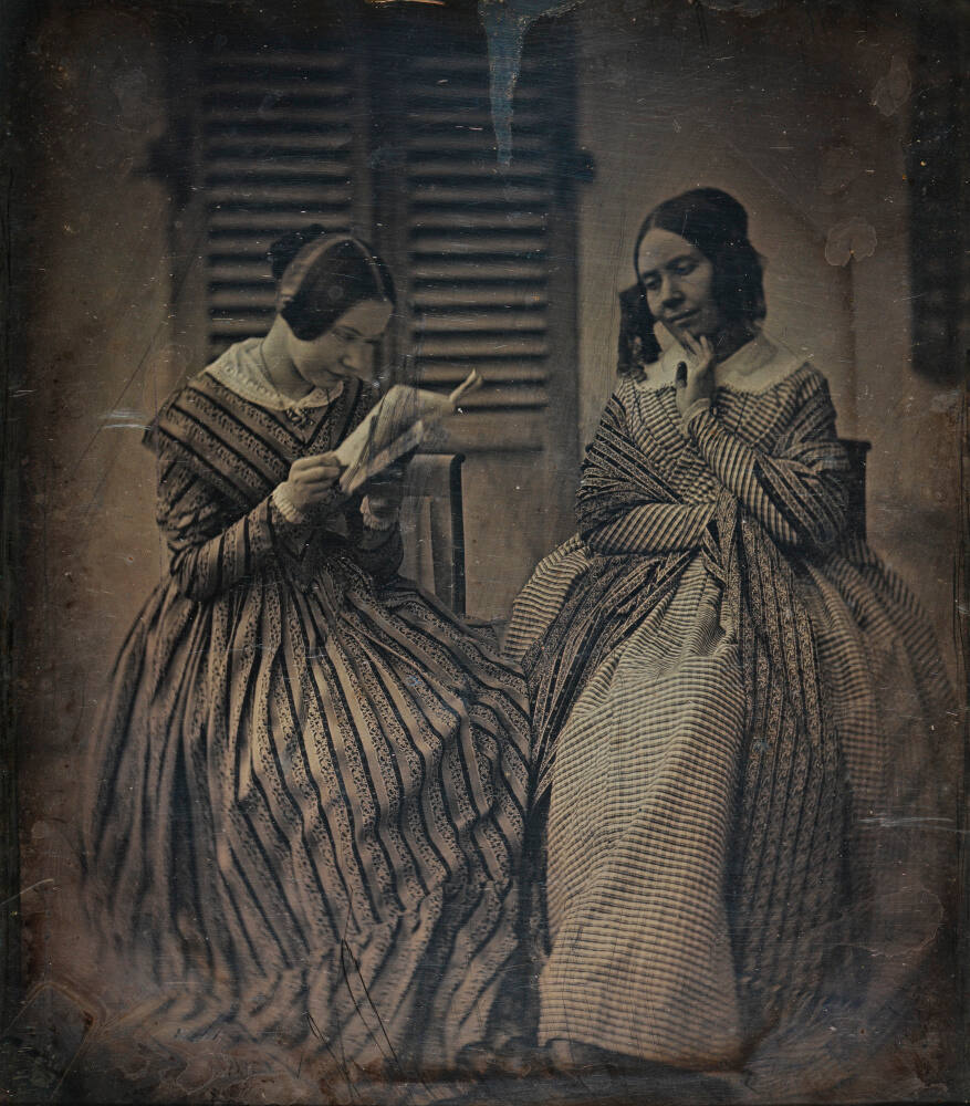 Two ladies reading a letter