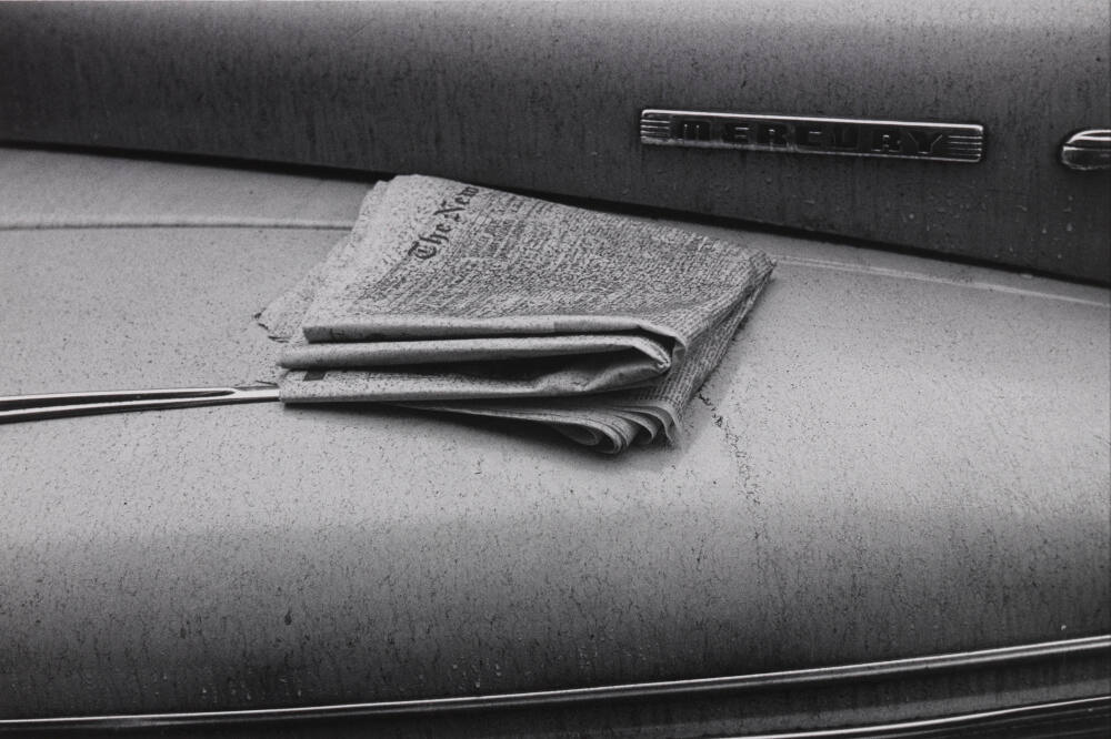 Untitled (Newspaper on car)