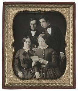 Group of Four Reading a Letter