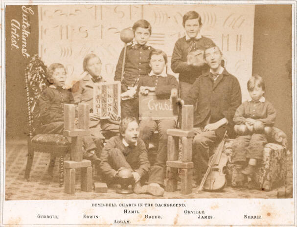 Dumb-Bell Charts in Background (Group at Pennsylvania Training School for Feeble-Minded Children)