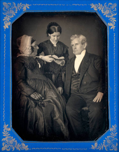 Girl Reading to Elderly Couple