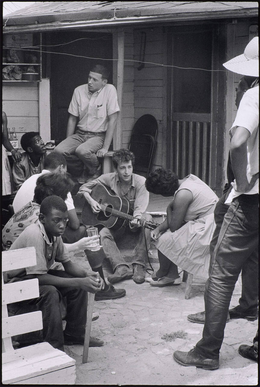 Bob Dylan plays behind the SNCC office, Greenwood, Mississippi