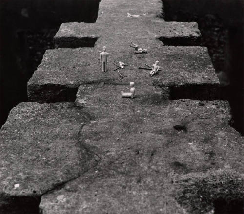 Untitled (dolls on rock wall)