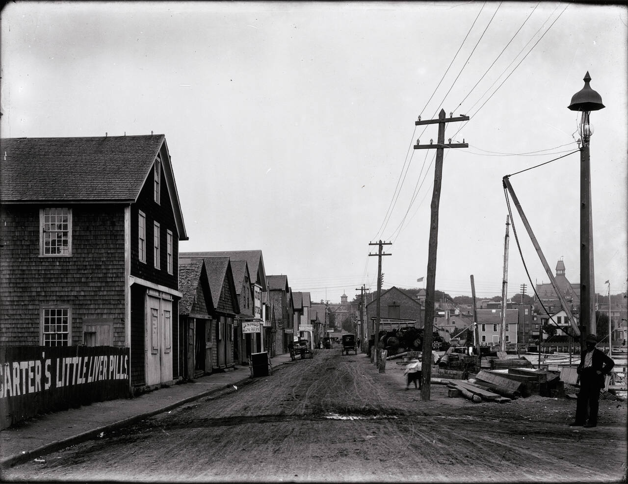 Looking East on a street called Long Wharf with Ole (sic) Colony House in the distance