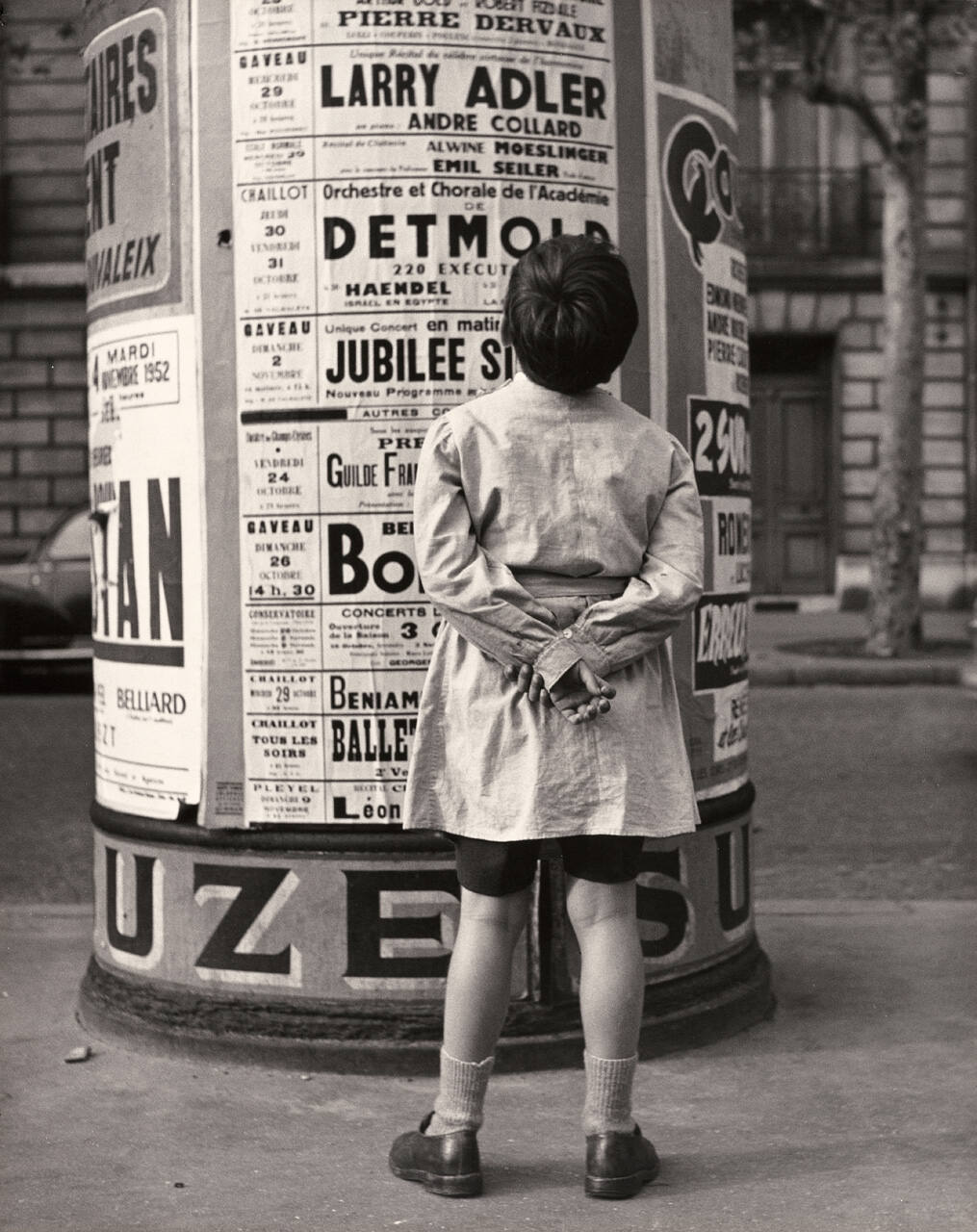 Untitled (Boy reading sign on kiosk)