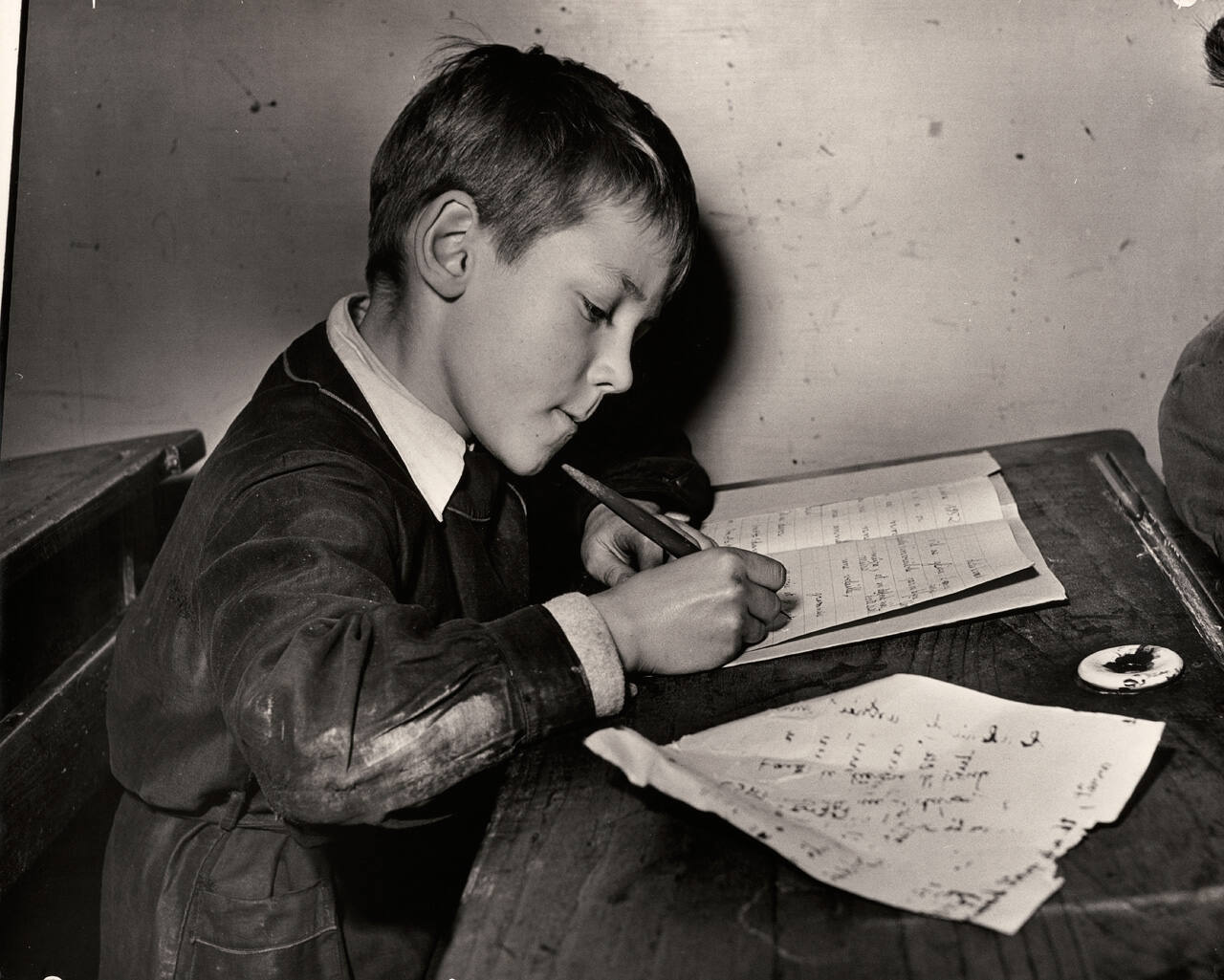 Untitled (Boy writing on school desk)