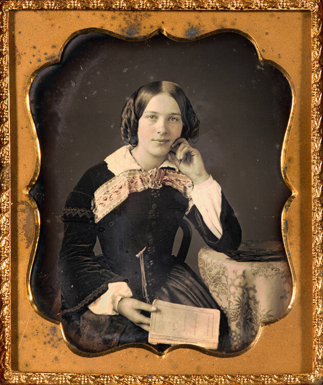 Woman holding copy of "Sunbeam and Shadows"