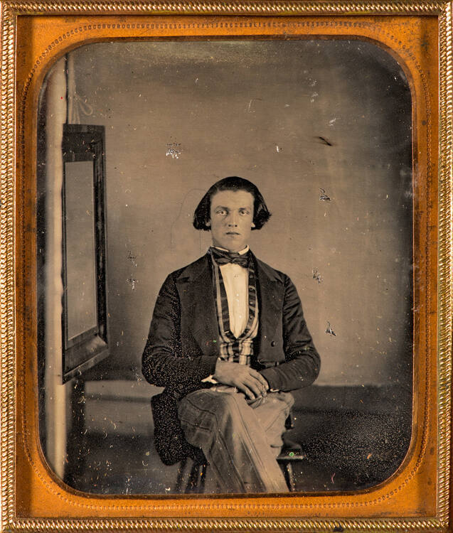 Man seated next to studio mirror