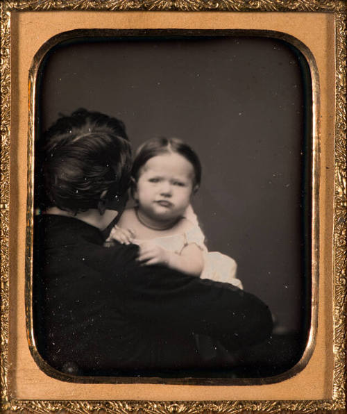 Man viewed from behind with child looking over shoulder