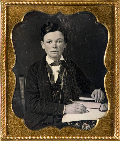 Young male student with book and pen in hand