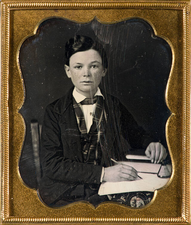 Young male student with book and pen in hand