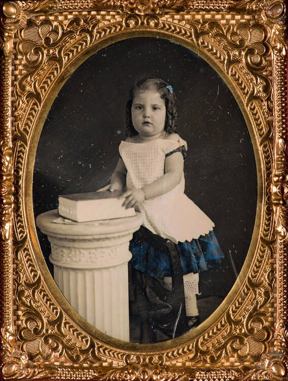 Portrait of a child with book on column