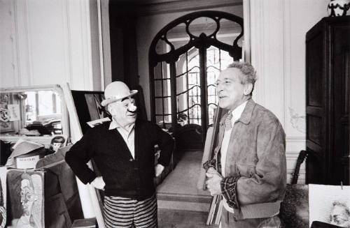 Masked as Italian clown, Picasso welcomes Jean Cocteau to the villa