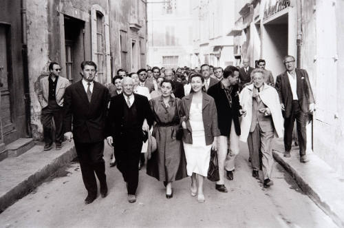 Paulo, Jacqueline, daughter-in-law Christine, art expert John Richardson, poet-playwright Jean Cocteau (with cape), and art historian Douglas Cooper, on sidewalk to Arles bullfight