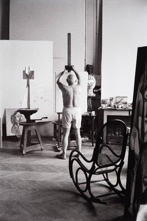 Picasso ready to paint, encircled by earlier portraits of Jacqueline