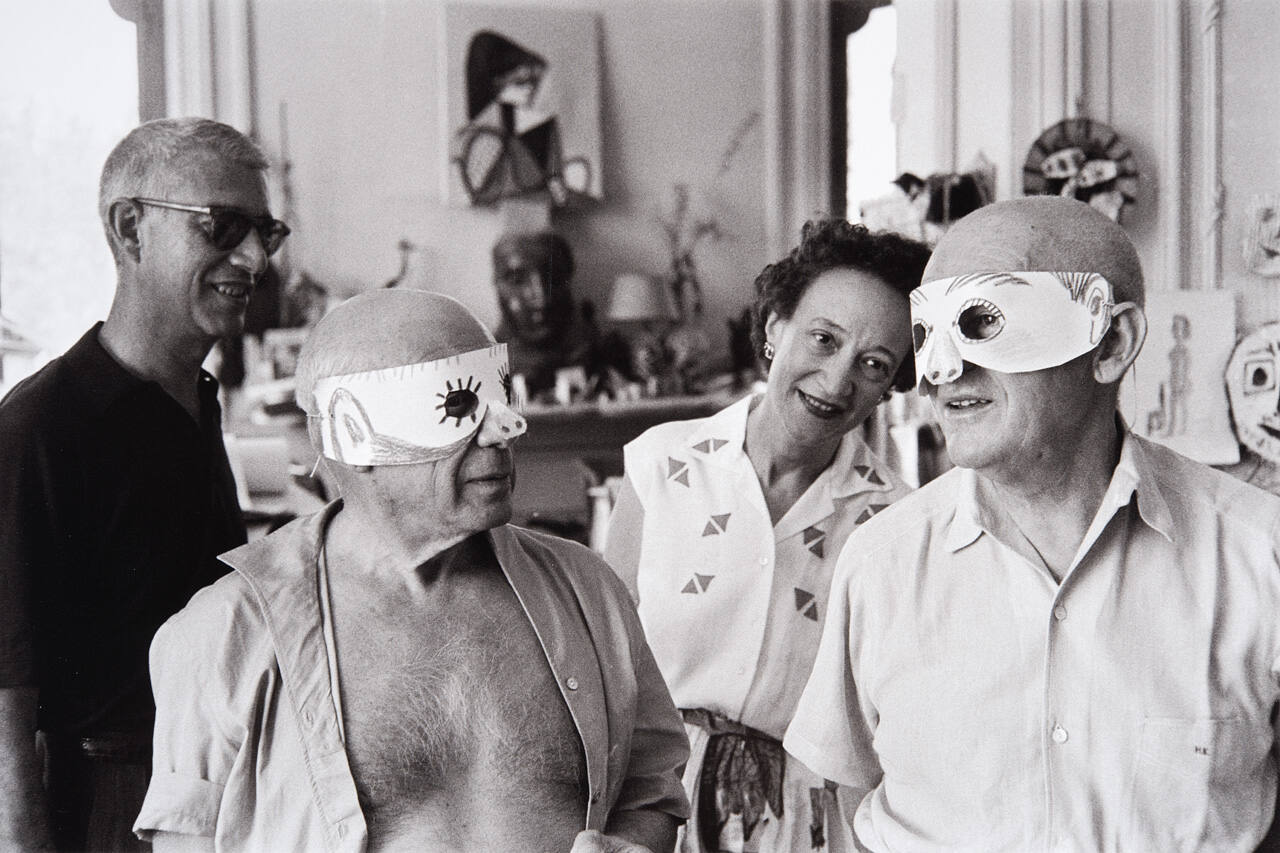 Picasso's home at Villa La Californie was a world apart, an enchanted place where the artist's oldest and newest friends seemed drawn by the same magic that had lured so many others to his bleak studio soon after he arrived in Paris from Barcelona. Daniel-Henry Kahnweiler and Picasso wear masks while New York gallery owner Eleanor Saidenberg looks on
