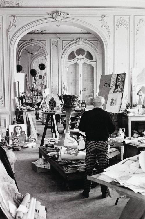 Pablo Picasso alone in his studio at La Californie. Jacqueline's charcoal portrait is at left.