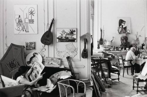 Picasso painting plates at the dining table, with Jacqueline reading