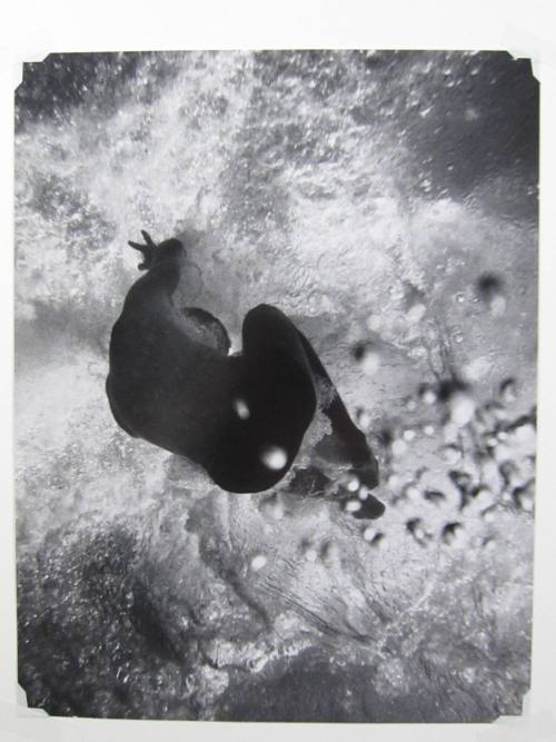 Crouching figure in water seen from below