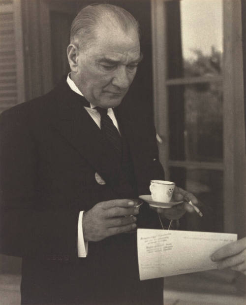 Kemal Pasha (Ataturk), dictator of Turkey does four things at the same time: holds cup of strong Turkish coffee, cigarette, also glass of brandy and looks at my pictures, Ankara, Turkey