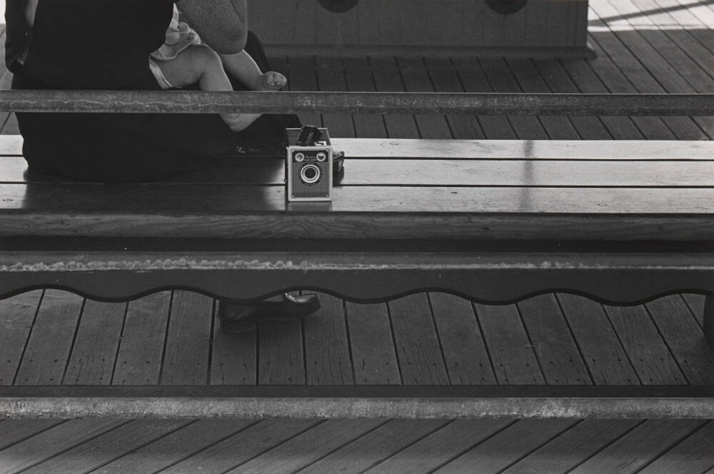 Untitled (Woman holding child on bench with camera beside her)